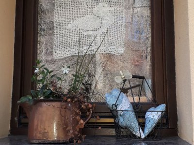 Fenster mit Gardine, Deko und einem Schild -Schwalben willkommen-